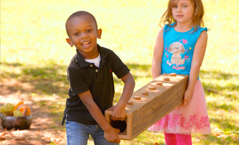 Two children carrying a long Outlast block.