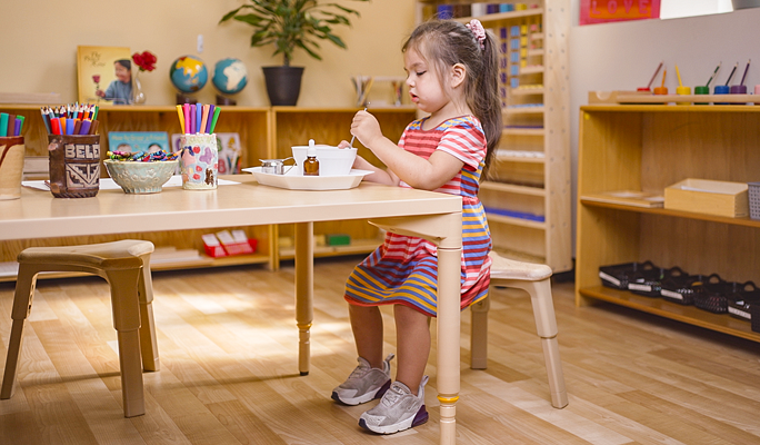 A child doing a craft on a table