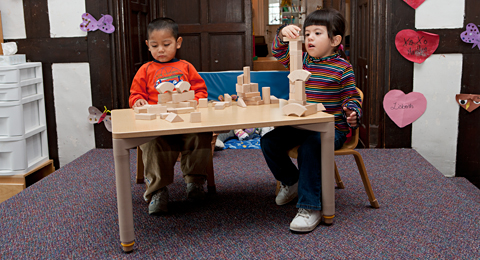 children stacking blocks on a table