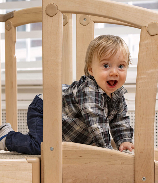 Toddler laughing through the railing of the Toddler Climber