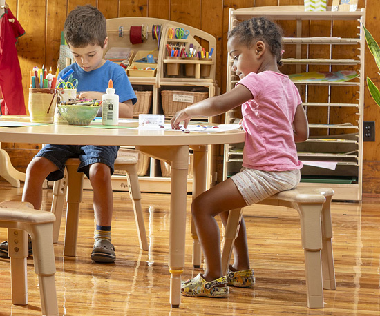 Two children engaged in art projec while seated on Grow-Right Stool
