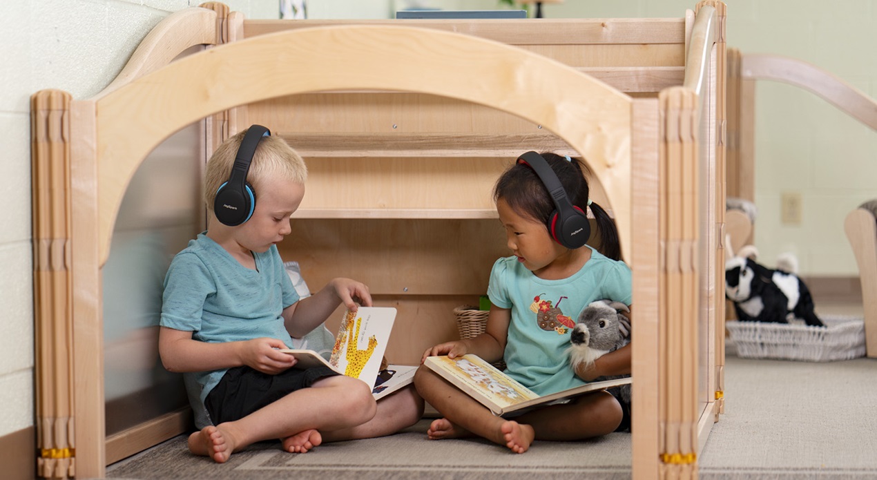 a preschool boy and girl wearing headphones in a classroom learning center