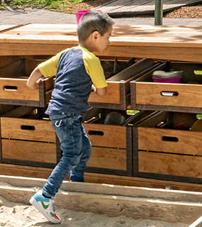 A child pulling a crate off an Outlast Sandbox Storage