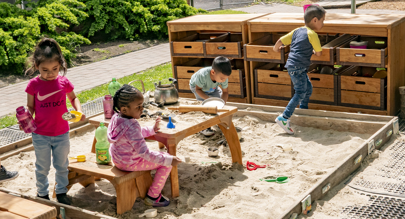 Children playing in a sandbox and accessing Outlast Sandbox Storage
