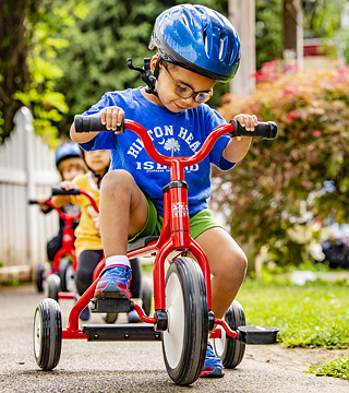 A child using a Community Playthings Trike