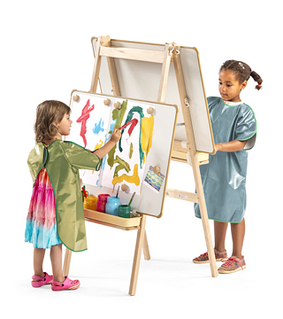 Two children with aprons painting at an easel