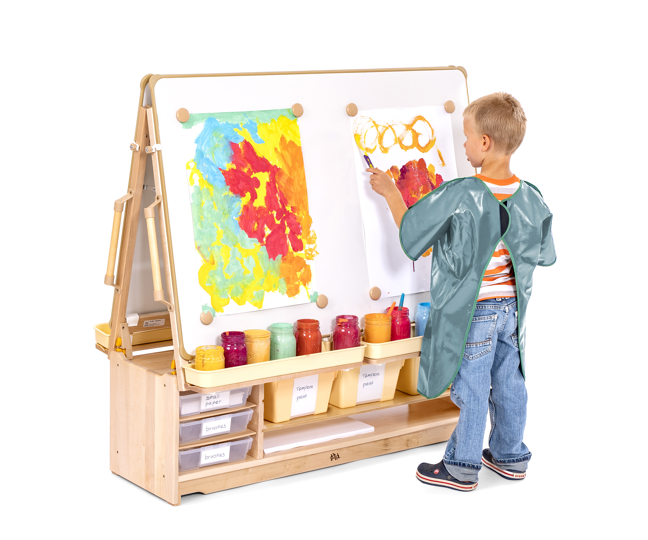 Boy with blue apron painting at an Art Island