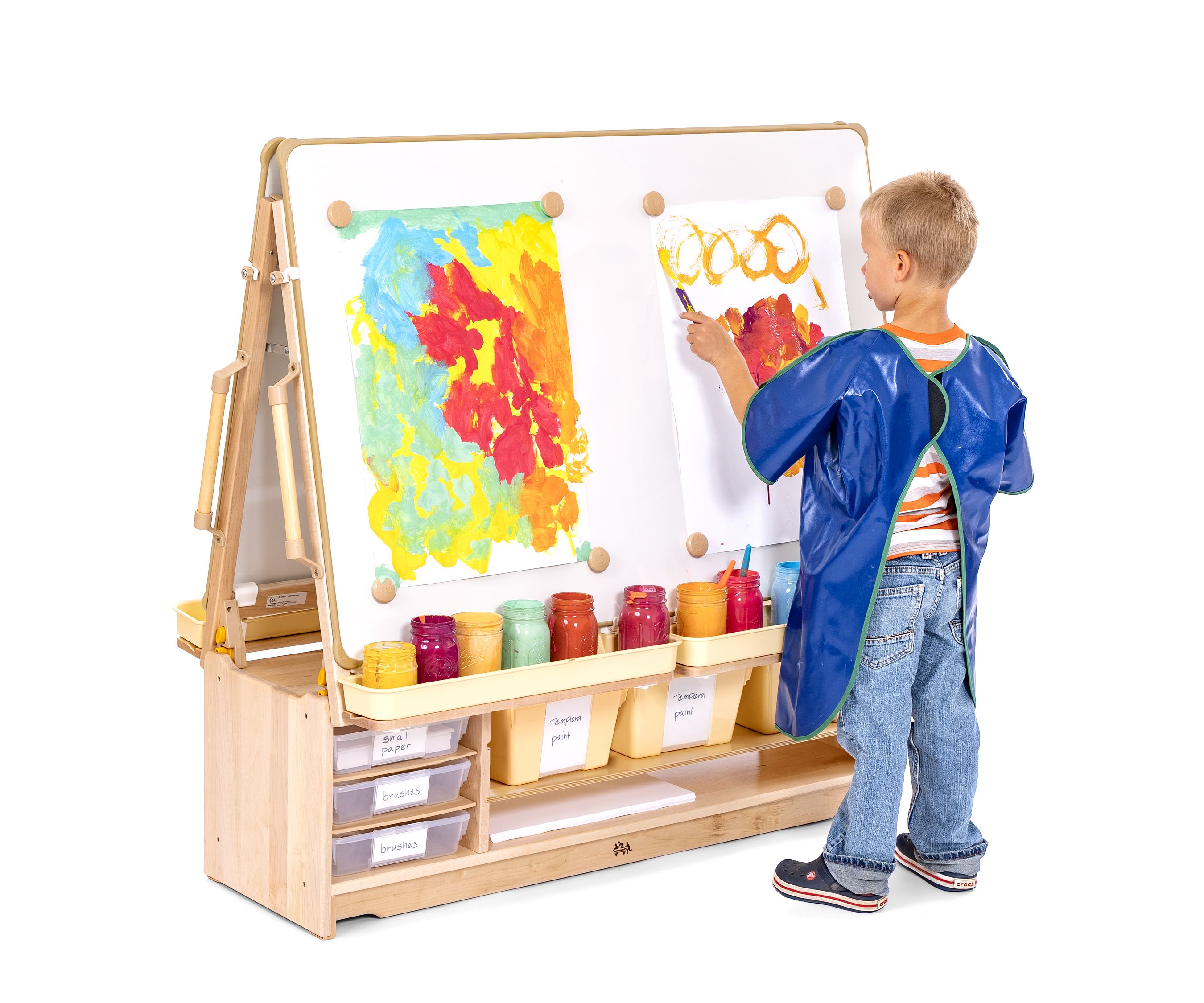 Boy with blue apron painting at an Art Island