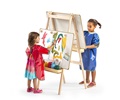 Two children with aprons are using an easel