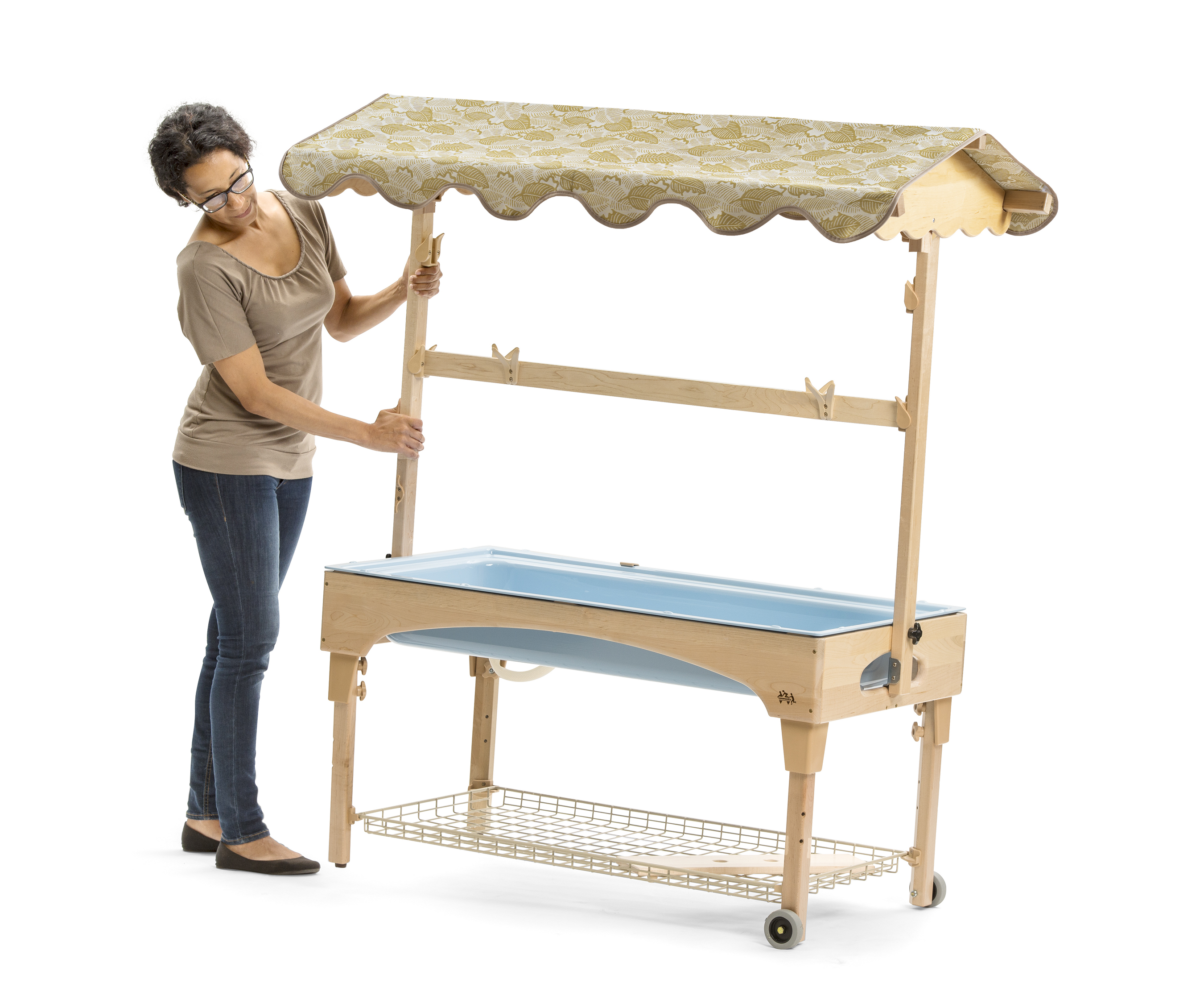 A teacher moving a large sand and water center