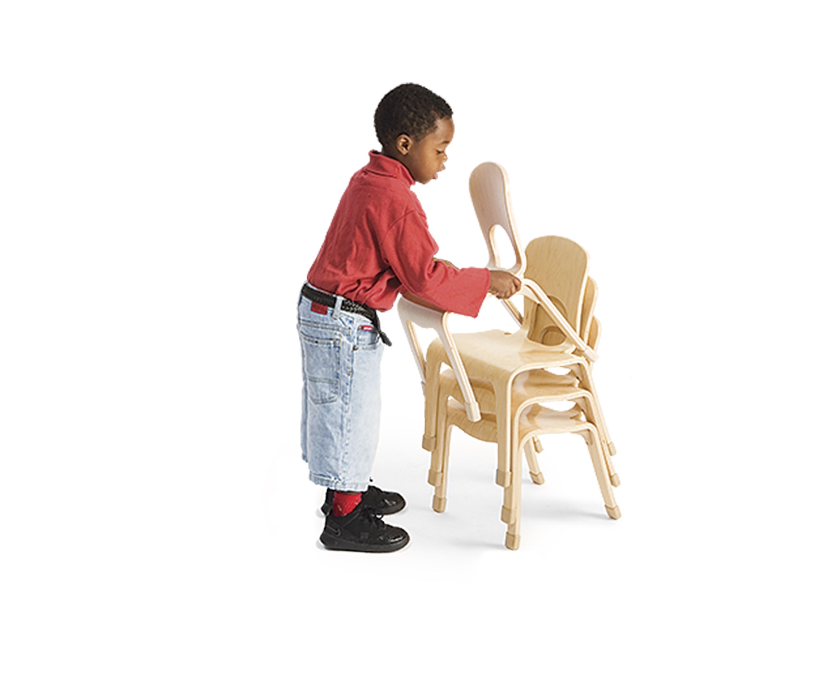 A boy is stacking classroom chairs