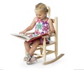 Child sitting in a wooden rocking chair and reading a book