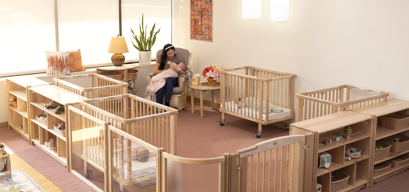 an Infant nap area with cribs  and a space divider