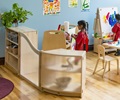 A kindergarten classroom with a room divider consisting of two shelves and a clear wave panel