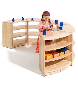 a child standing behind a wooden shelf