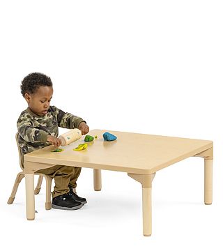a child playing with playdough at a table