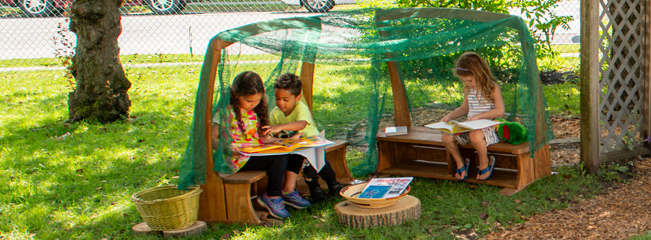 Children reading books under the Outlast Arbor