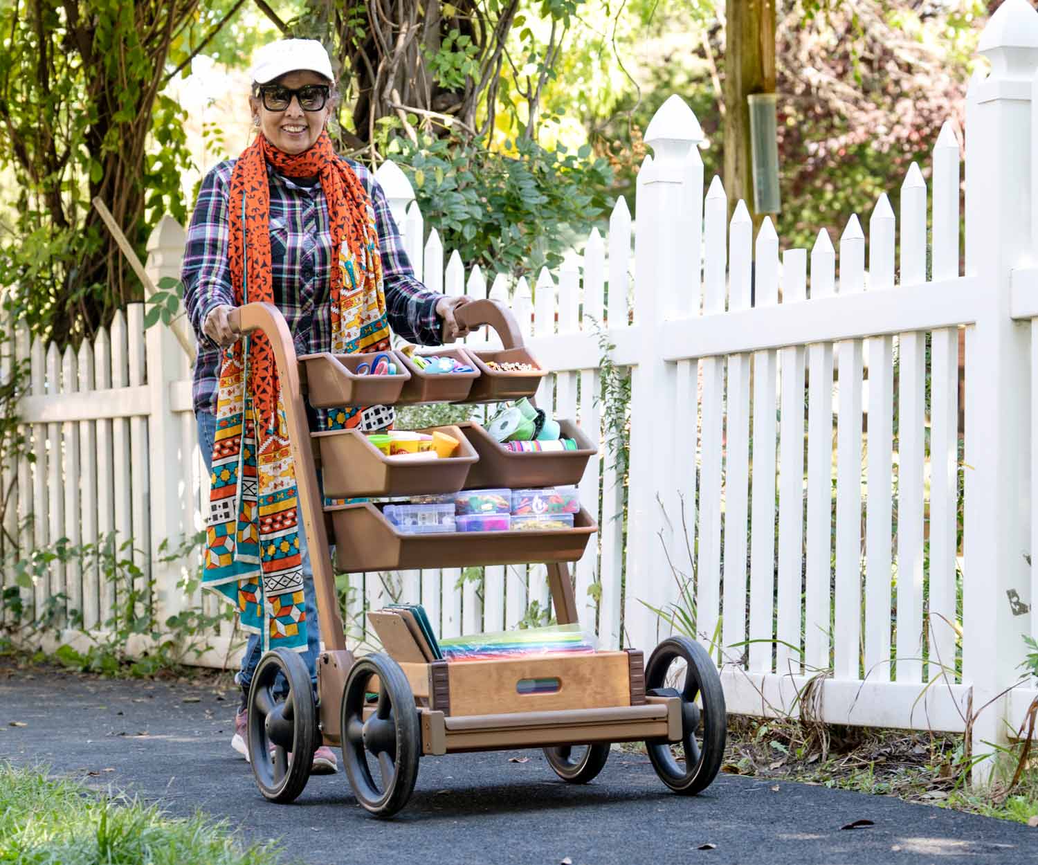 cheerful lady pushing art cart full of supplies