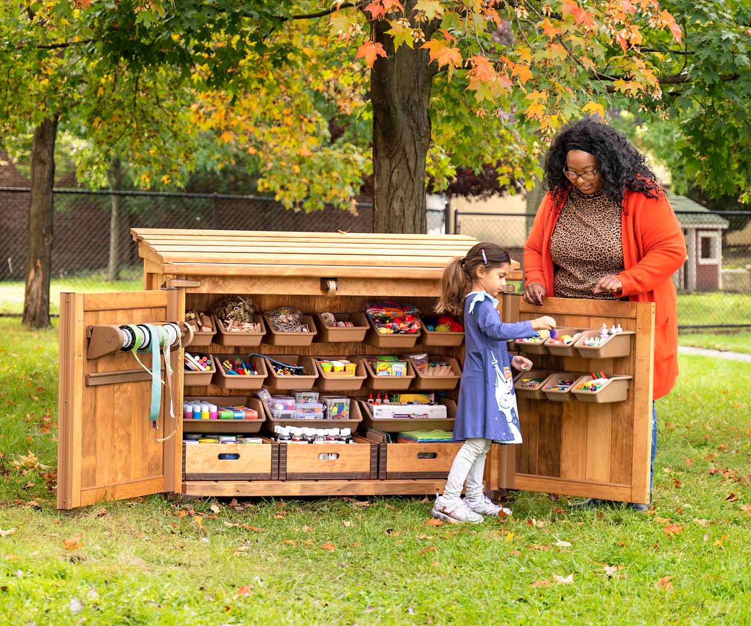 Child accessing art supplies from art shed