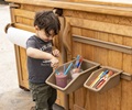 preschool boy washing paint brushes in outdoor art studio
