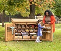 teacher and little girl checking out the art storage shed outdoors