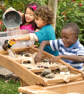children playing with sand on a table