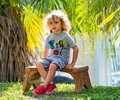 Child sitting on Outlast Seat under a willow tree