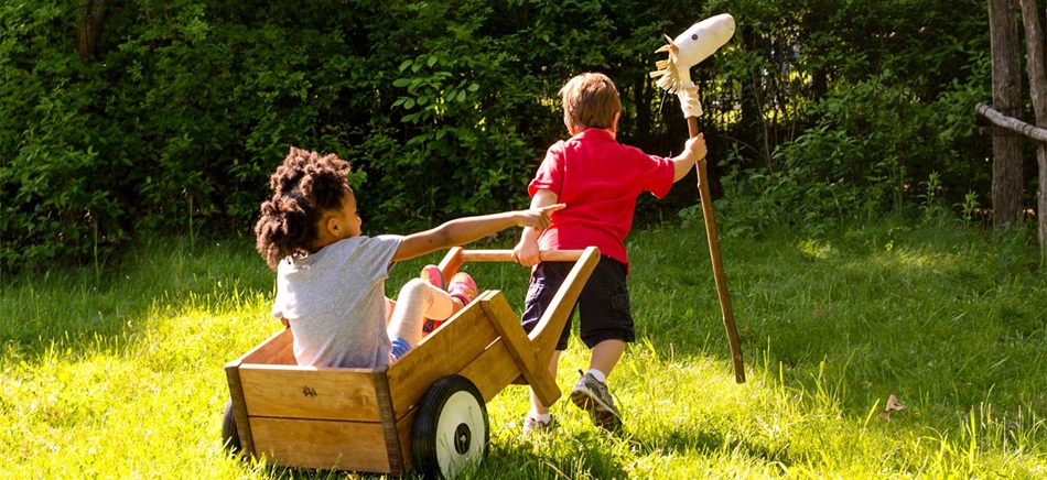 preschool kids playing with hobby horse and wheelbarrow