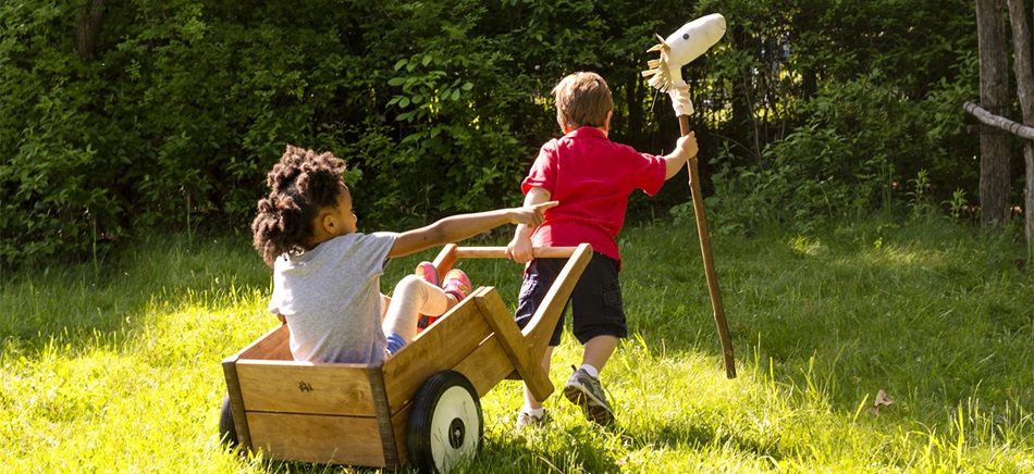 preschool kids playing with hobby horse and wheelbarrow