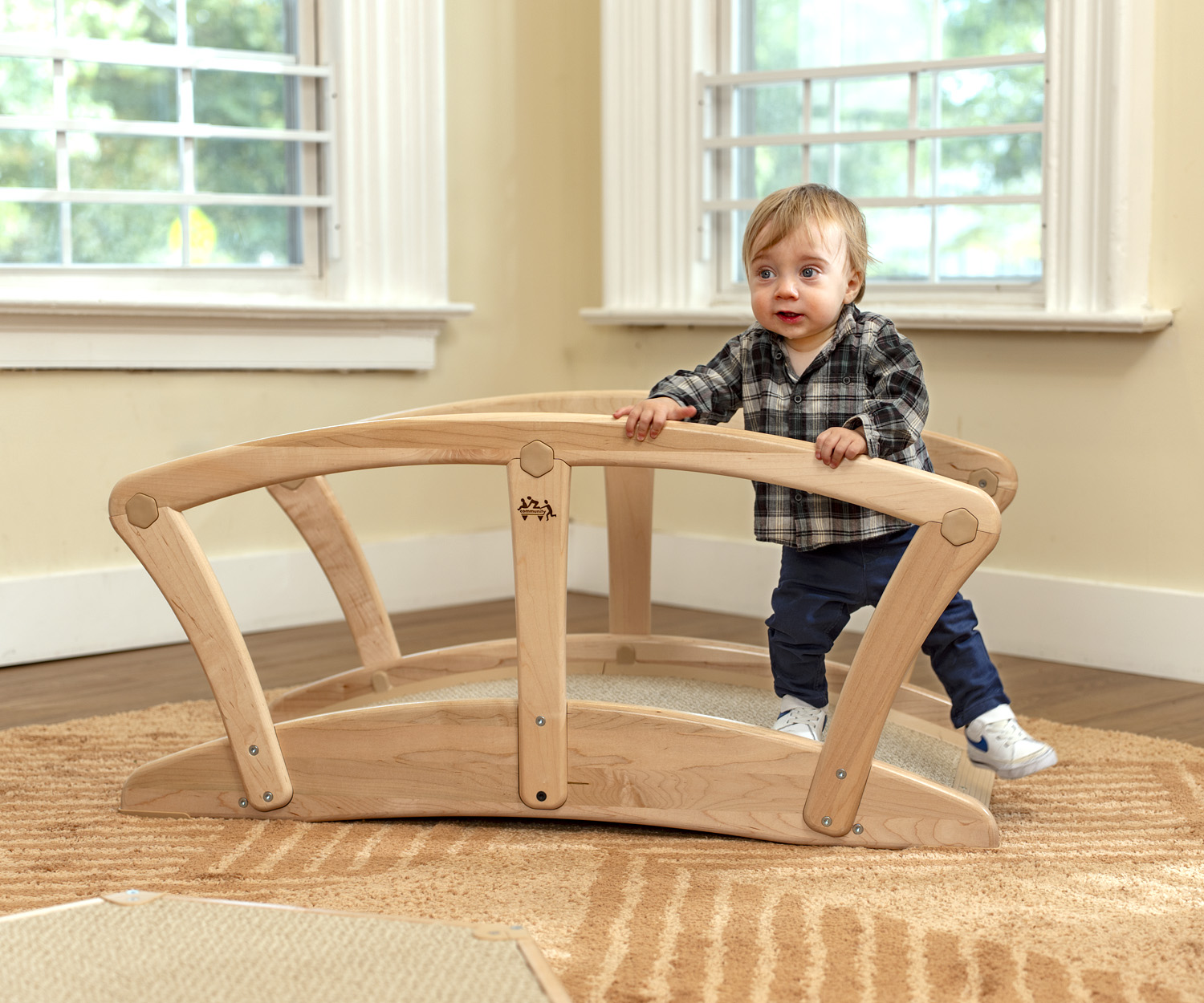 a toddler playing on a wooden bridge