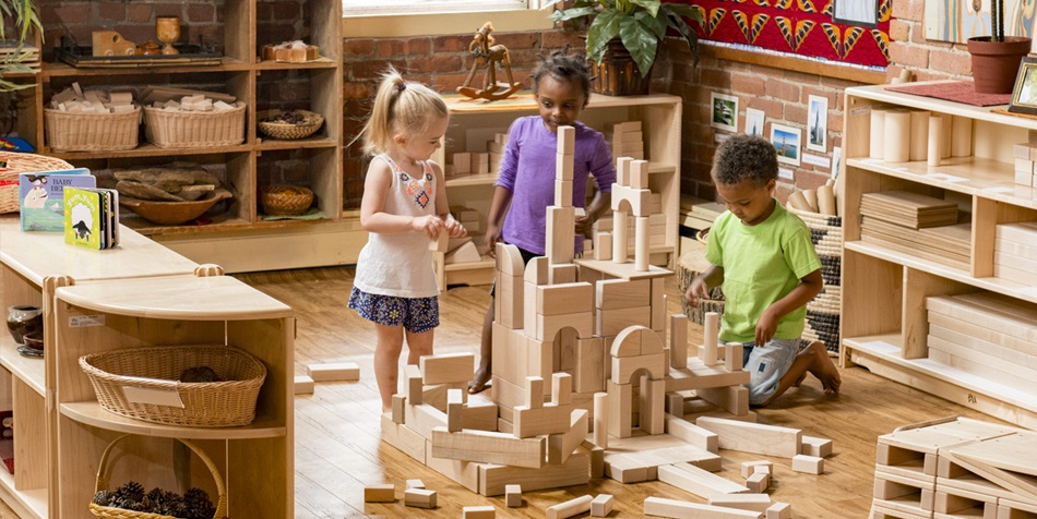 children building a tower out of unit blocks