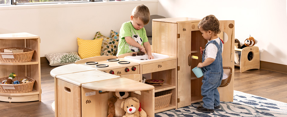 two little boys playing in the toddler play kitchen