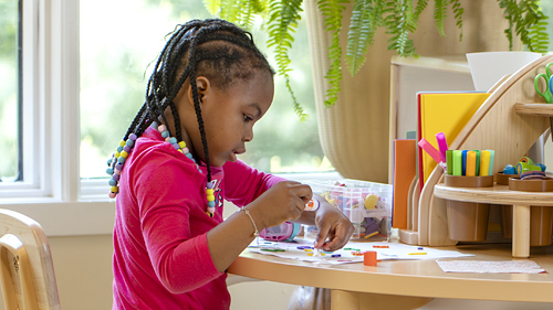 PreK child creating art at table