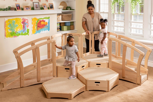 Children playing on Toddler Climber with teacher supervising