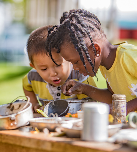 Children intently building mudpies