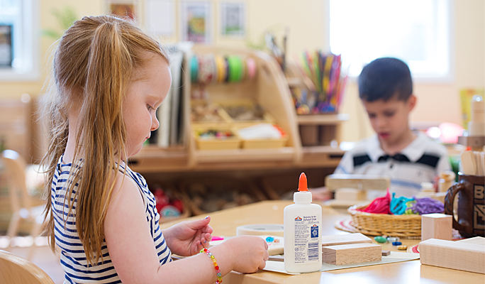 A child doing a craft on a table